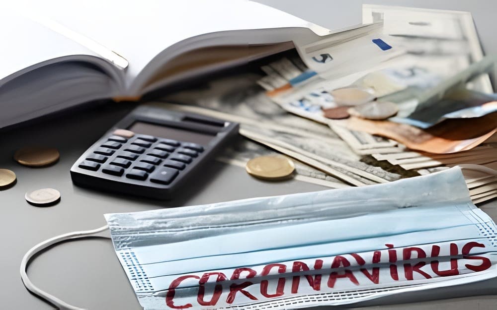 Een mondkapje met het woord coronavirus, naast een rekenmachine en bankbiljetten.